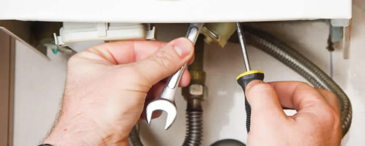 Boiler repair technician tightening pipe fittings and connections in La Jolla, CA