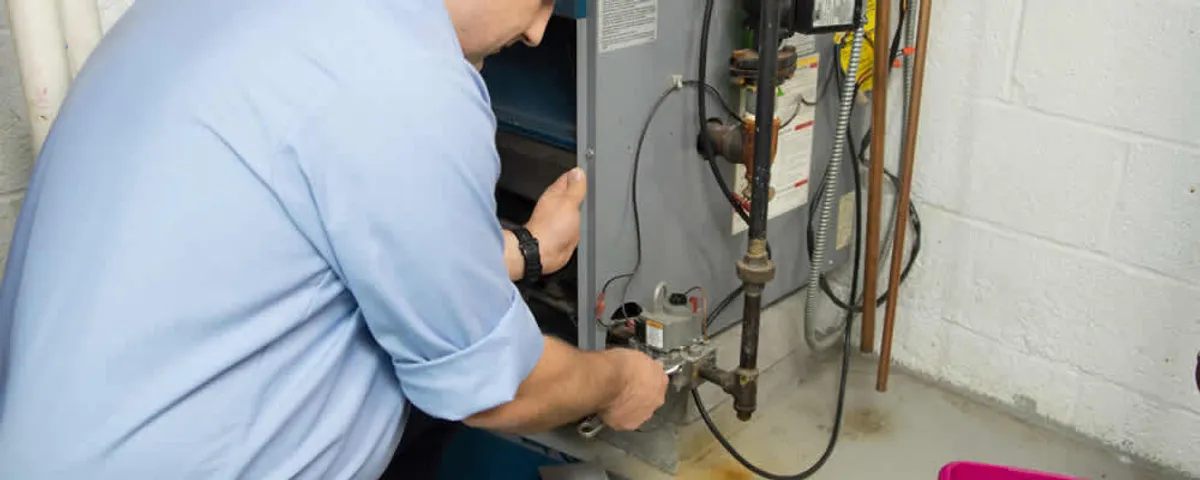 Furnace repair technician inspecting and servicing a home heating system in La Jolla, CA