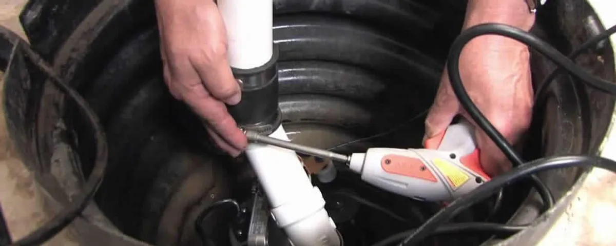 Sump pump installation technician connecting PVC discharge piping in La Jolla, CA