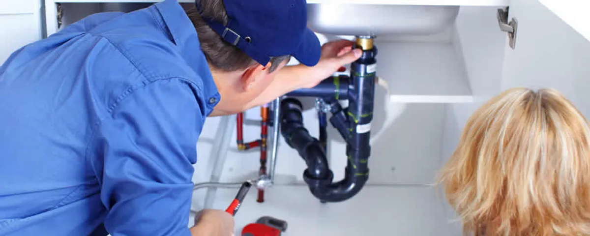 Plumber repairing under-sink drain pipes and fittings in La Jolla, CA
